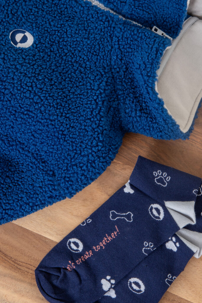 blue zip sweater with embroidered logo and matching branded socks 